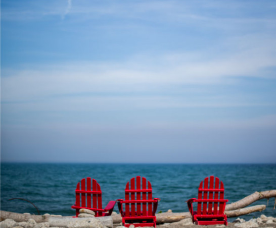Red adirondack chairs overlooking the lake.