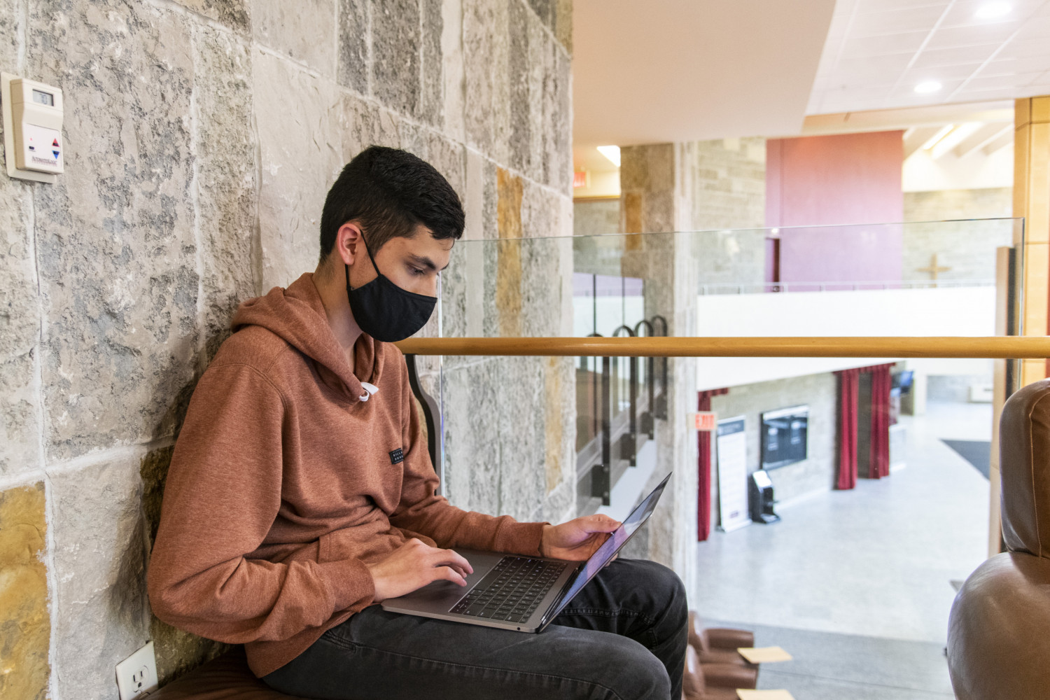 A student takes a study break between classes on the second floor of the Clausen Center.