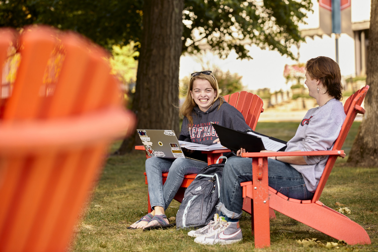 Students hang out in the red Adirondack chairs between classes.