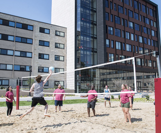 Students play volleyball outside The Tower.