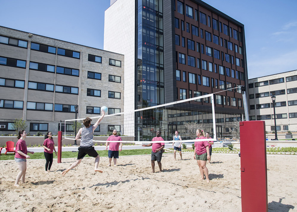 Students play volleyball outside The Tower.