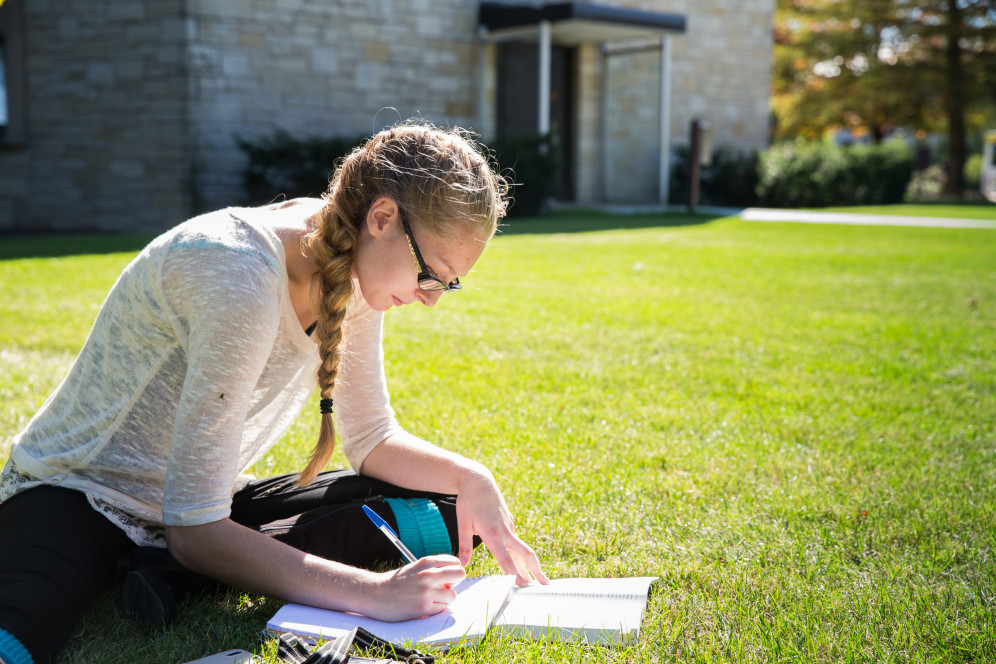 A student studies outside. Being an office writer is one of many student employment opportunities...