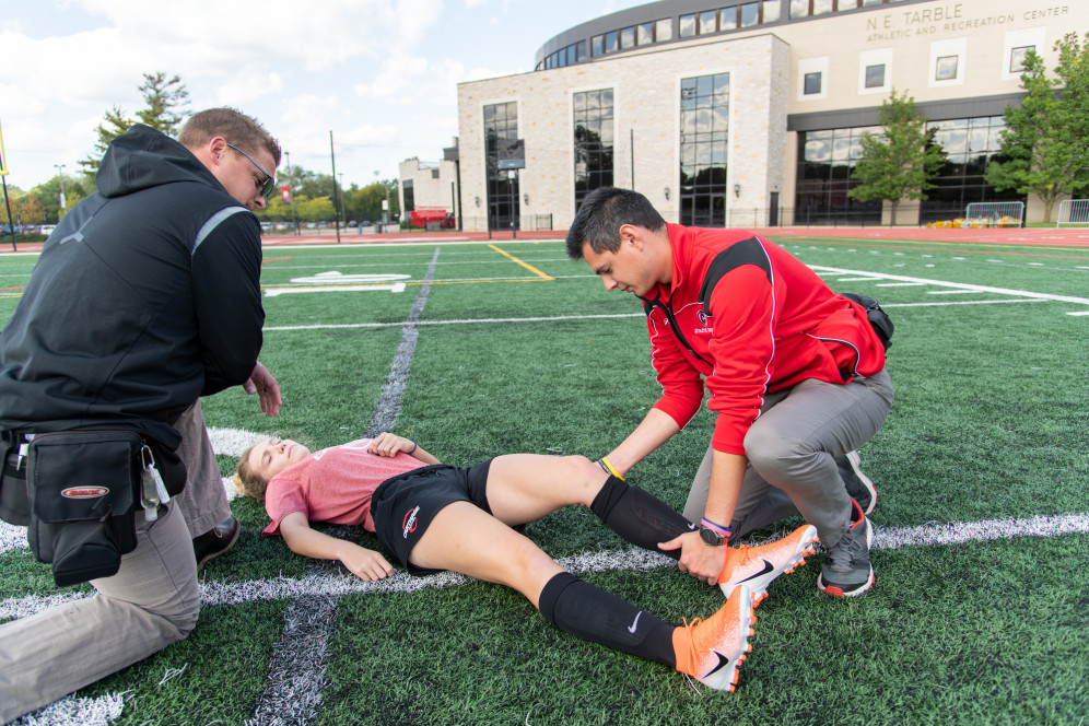 An athletic training student practices on a fellow student.
