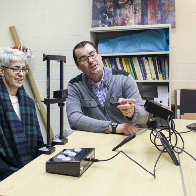 Profs. Leslie Cameron and Anthony Barnhart examine the technology helping them with their eye tra...