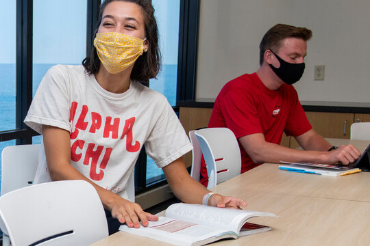 Students are physically distanced and wearing masks while studying in a classroom.