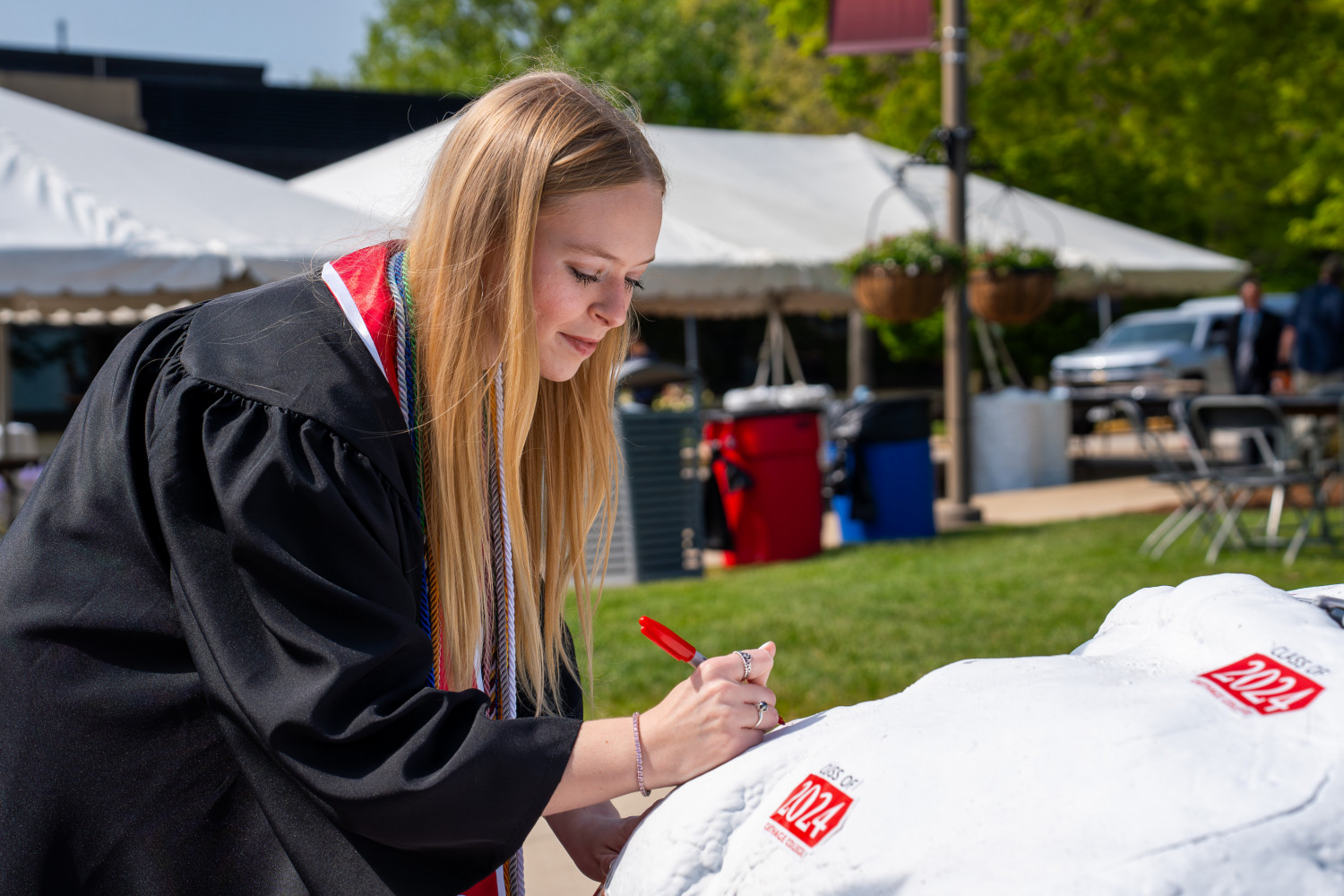 Graduates signing the Kissing Rock, a Carthage Commencement tradition.