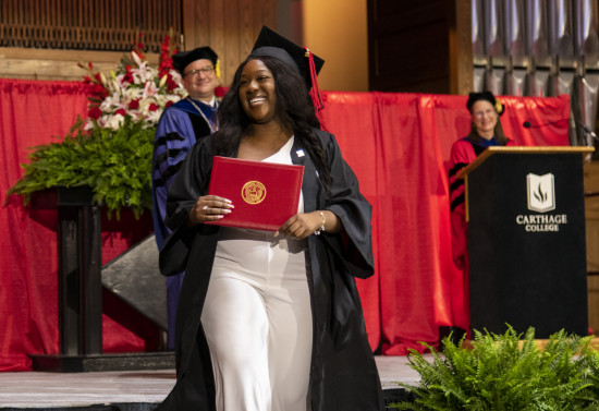 A 2023 Carthage College graduate beams as she leaves the Commencement stage after receiving her d...
