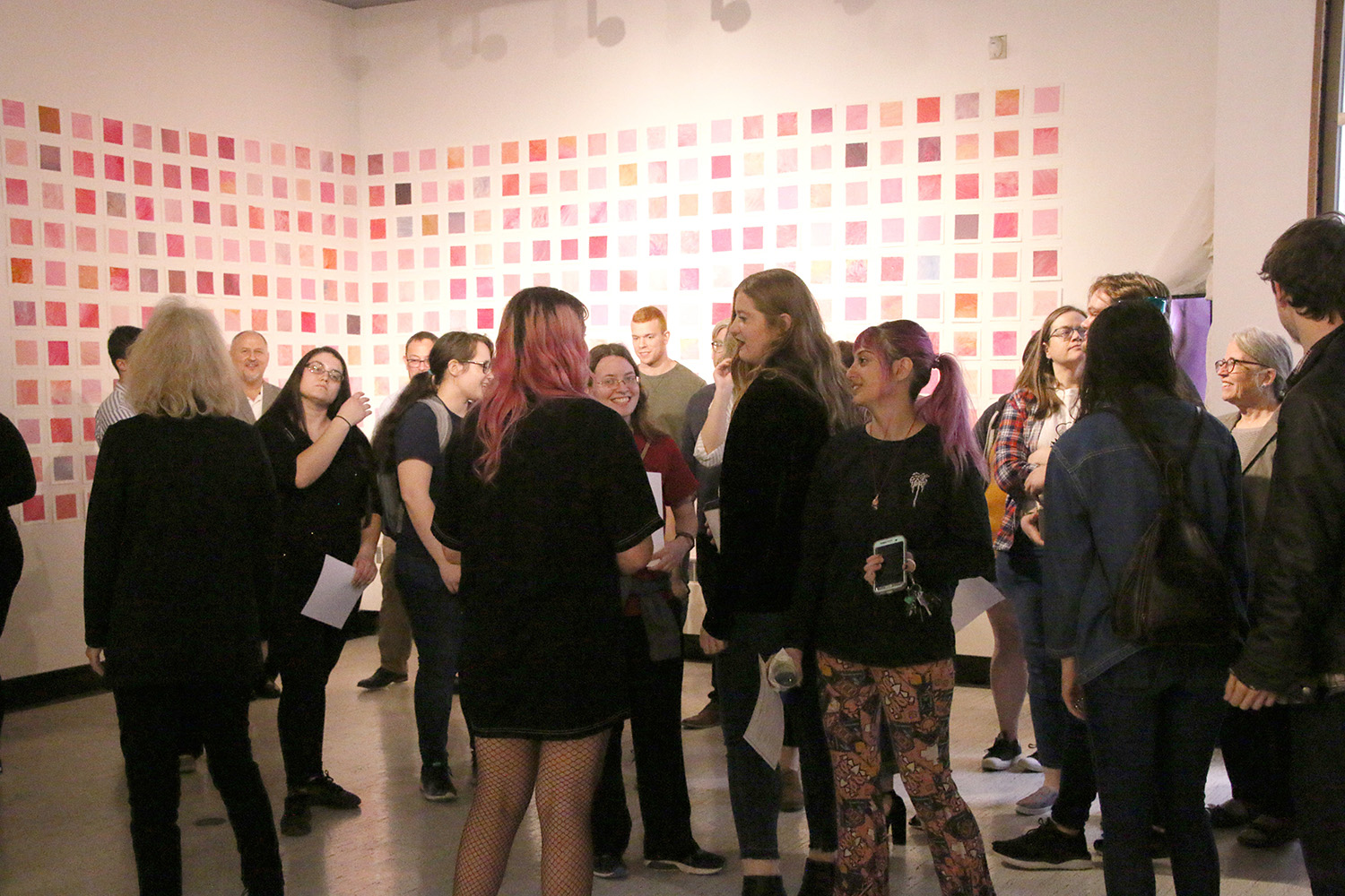 Students and visitors at a Spring 2019 Senior Thesis Opening. (in the background, paintings by Ha...