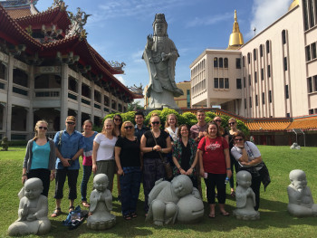 A group of students in front of a monastery in Asia.