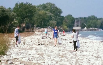Members of Carthage United to Rescue Earth (CURE) help clean up the Lake Michigan shoreline at Ca...