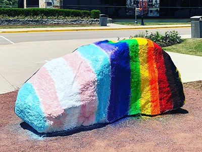 Kissing Rock with the Pride Flag painted on it.
