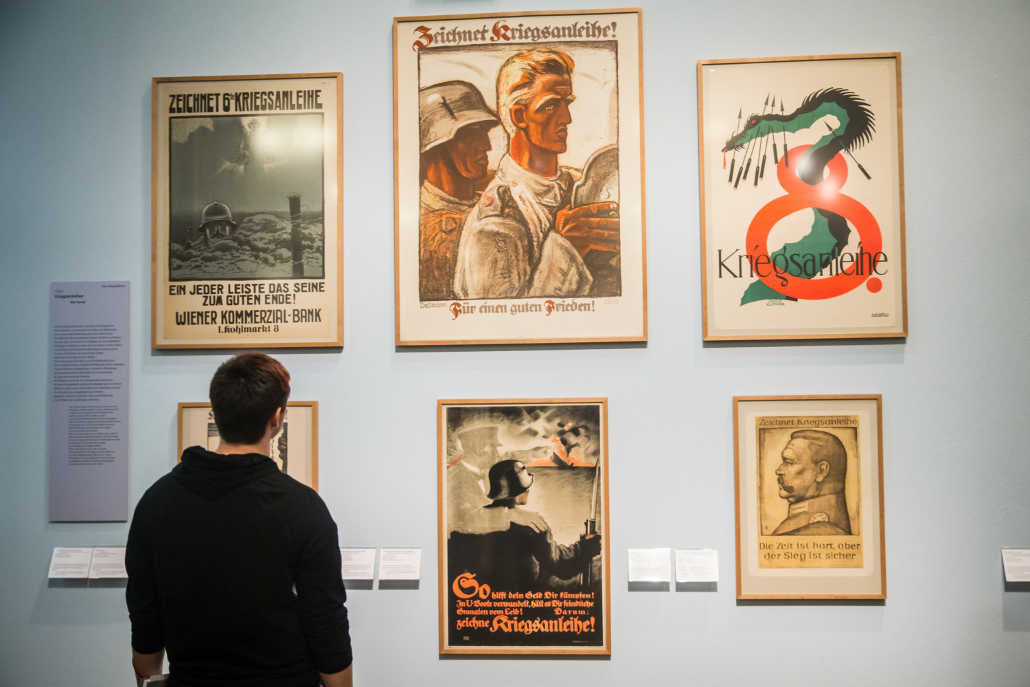 A student observes German military posters in a museum on the J-Term study tour to Germany.