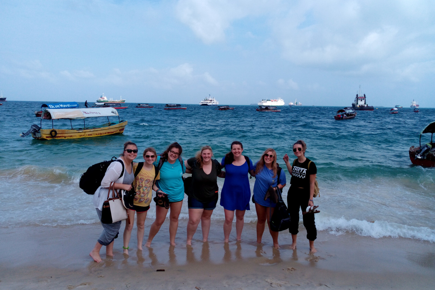 Students pose for a photo seaside on a J-Term study tour in Tanzania.