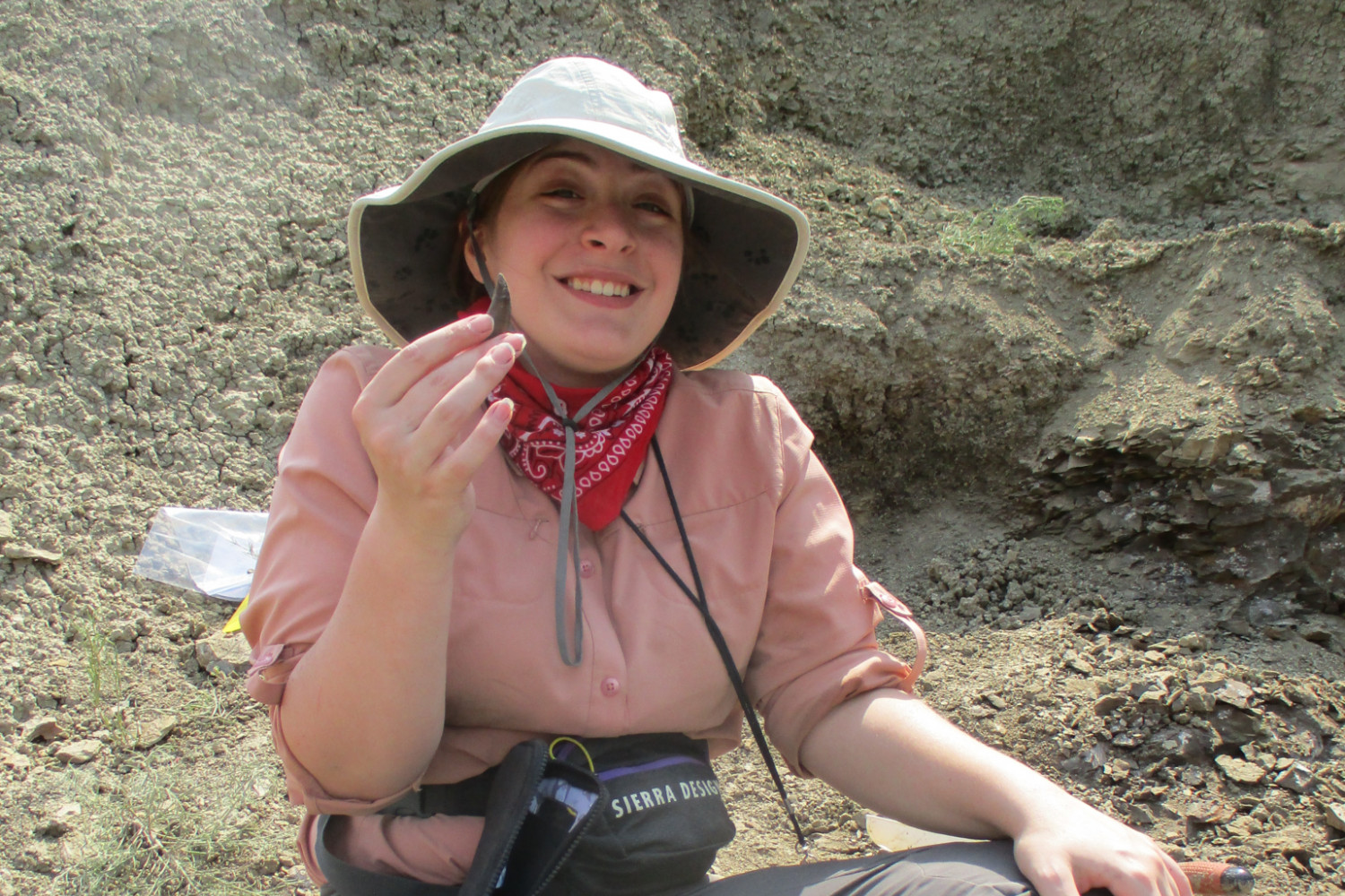 A paleontology student holding a fossil.