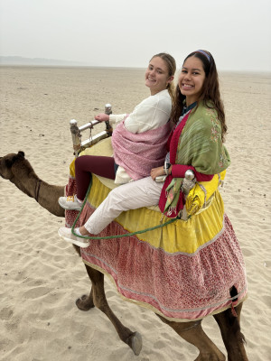 My teammate, travel buddy and best friend, Kailey, and I riding a camel on the other sided of the...