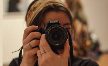 A Carthage College's photography major using a camera.