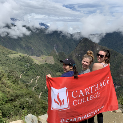 Carthage students pose with a Carthage flag while visiting Peru during January Term.