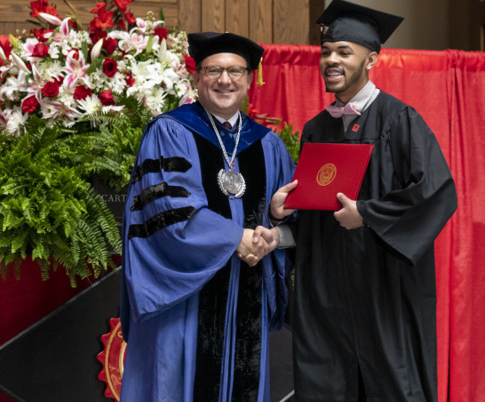 A graduate receives his degree from President Swallow.
