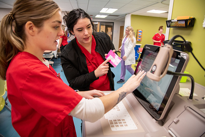 Carthage nursing majors practicing with laboratory equipment.