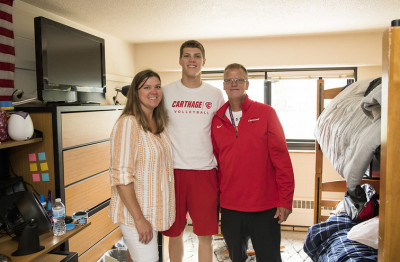 Parents say goodbye to their student in the dorm room.