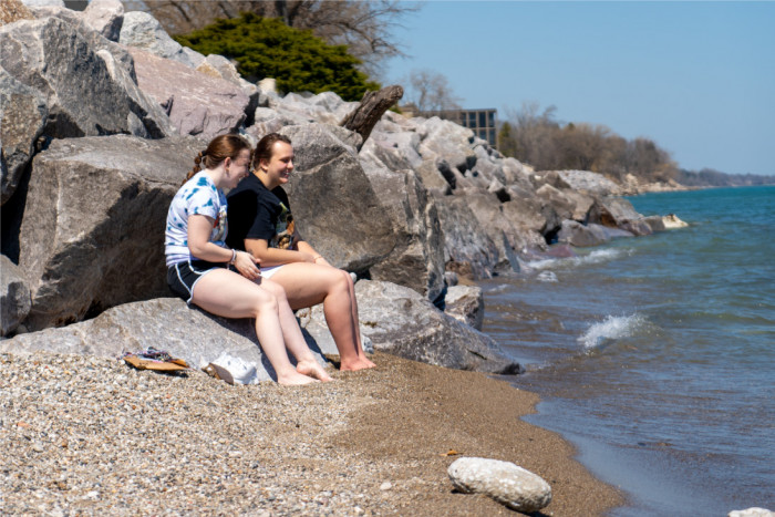 Students sitting in the sand off Lake Michigan.